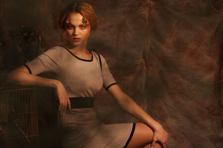 young fashion model sitting on a stool in drama decorationの写真素材