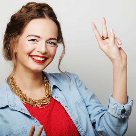 Happy smiling beautiful young woman showing thumbs up gestureの写真素材