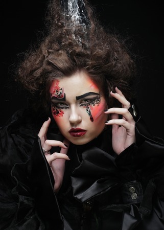 portrait of woman with artistic make-up in blue smoke, party themeの写真素材