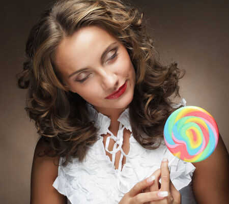 Young pretty woman with colorful lollipopの写真素材