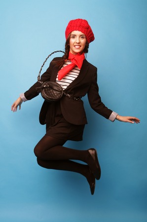 Beautiful girl in a red beret. French style. Over blue background.の写真素材