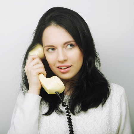young happy woman with vintage phone, studio shotの写真素材