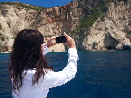 young woman photographs the island in Greece, travel in Zakinthosの写真素材