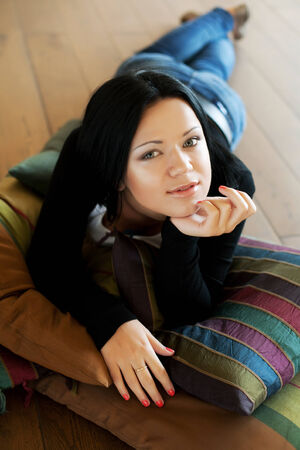 Portrait of a smiling young woman lying on the flooの写真素材