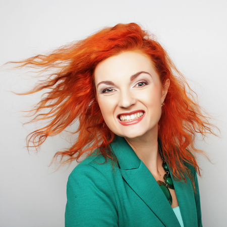 Young happy red woman with wind in hairの写真素材