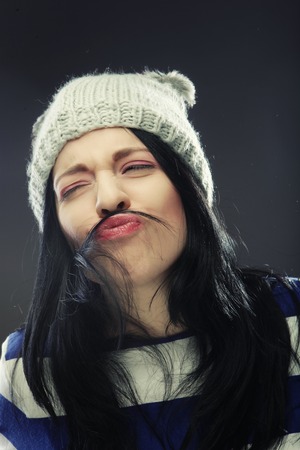 Playful young woman in funny winter hatの写真素材