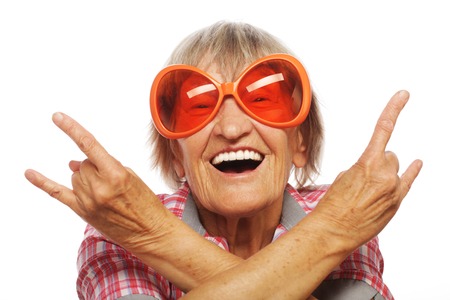 Senior woman wearing big sunglasses doing funky action isolated on white backgroundの写真素材