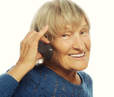 Smiling old lady communicating through mobile phoneの写真素材