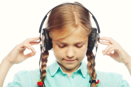 Beautiful happy little girl with headphones. Isolated on white.の写真素材