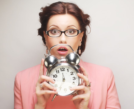Young fun businesswoman with alarmclockの写真素材