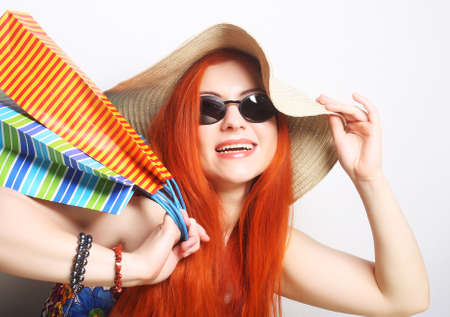 attractive redhair shopping woman wearing sunglasses and hatの写真素材