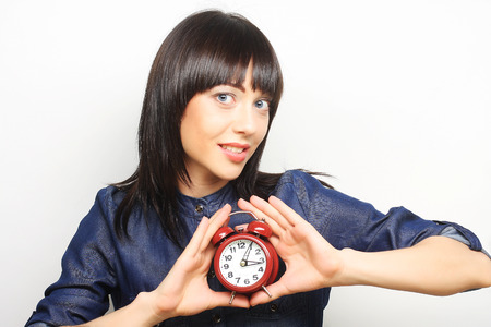 Young fun woman with alarmclockの写真素材