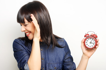 Young fun woman with alarmclockの写真素材