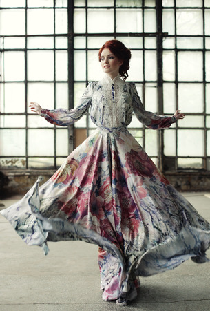 young elegance woman with flying dress in palace roomの写真素材