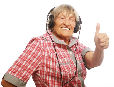 Funny old lady listening music and showing thumbs up. Isolated on white.の写真素材