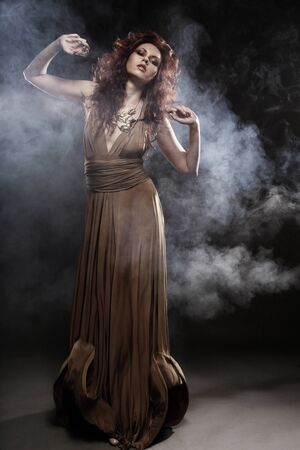 beautiful young woman in beige long dressの写真素材
