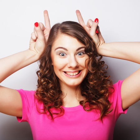 Funny woman doing hand sign. Studio shot.の写真素材