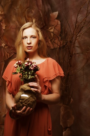 beautiful girl with dry roses in decorationの写真素材