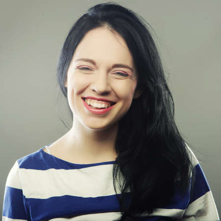 Beautiful young happy brunette woman. Studio shot.の写真素材