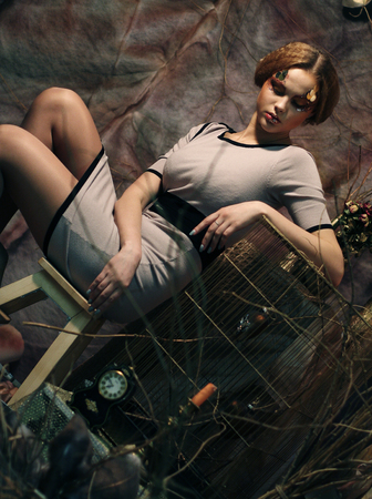 young fashion model sitting on a stool in drama decorationの写真素材