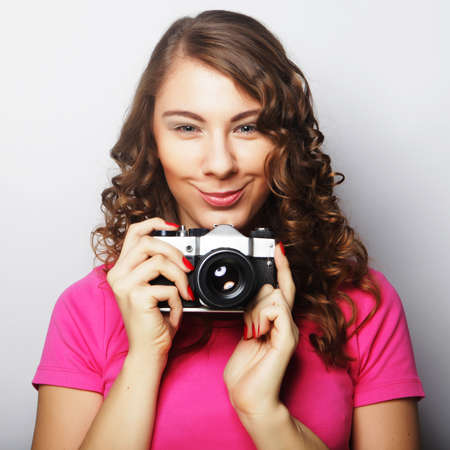 young curly woman with vintage cameraの写真素材