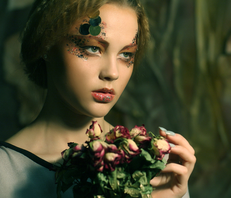 beautiful girl with dry roses in decorationの写真素材