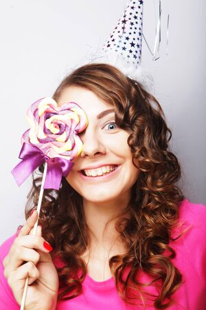 Funny curly woman  holding big lollipop. Birthday party.の写真素材