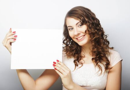 Young curly woman holding blank cardの写真素材