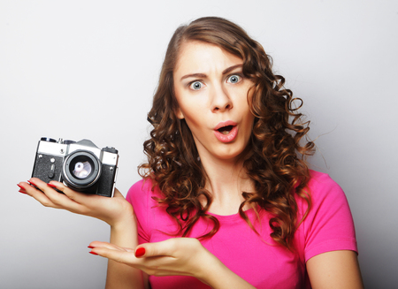 young curly woman with vintage cameraの写真素材