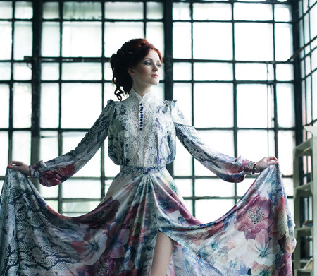 young elegance woman with flying dress in palace roomの写真素材