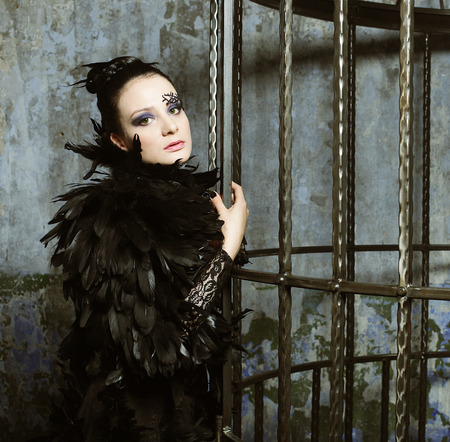 Fashion model in fantasy dress posing in steel cage.の写真素材