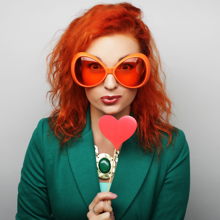 Party image. Playful young women holding a party heart and glasses.の写真素材