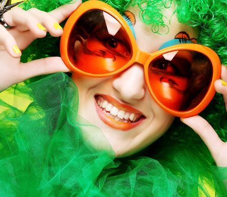 Happy young  woman with green hair and carnaval glassesの写真素材