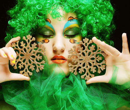 Beautiful lady with artistic make-up holding Christmas decorations.Doll style.の写真素材