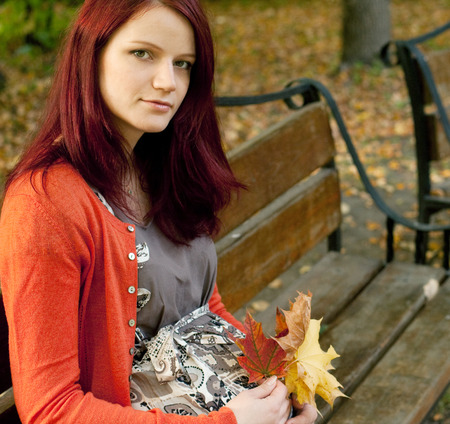 pregnant woman walking in autumn parkの写真素材