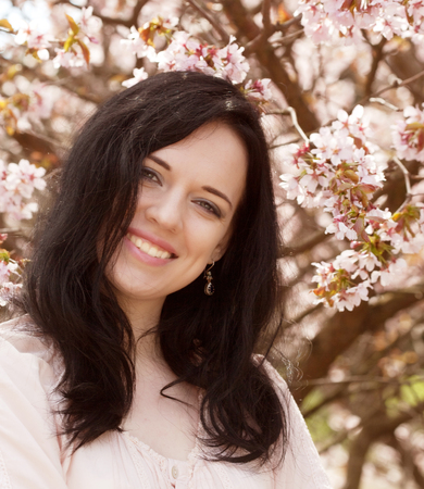 Beautiful young woman in blossom gardenの写真素材