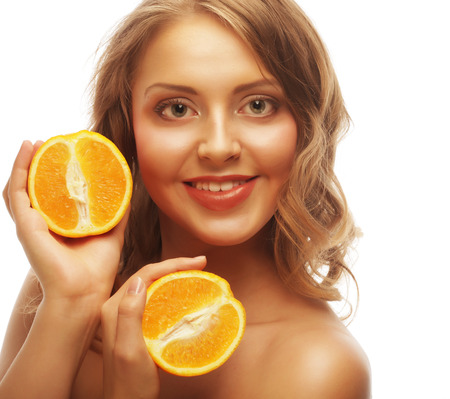 Beautiful close-up young woman with orangesの写真素材