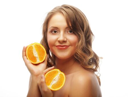 Beautiful close-up young woman with orangesの写真素材