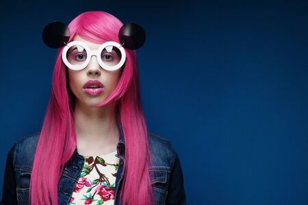 Beautiful fashion model  with pink hair and make-up wearing big sunglassesの写真素材