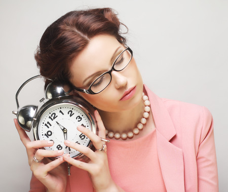 Young fun businesswoman with alarmclockの写真素材