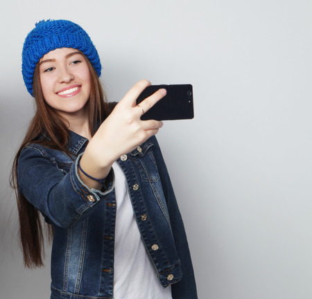 Girl take a self portrait with her smart phoneの写真素材