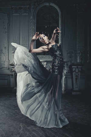 young elegance woman with flying dress in palace roomの写真素材
