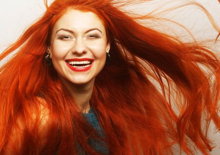 Beautiful young happy woman with long flowing red hairの写真素材
