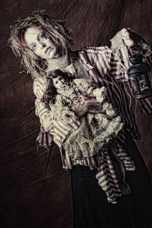 crazy woman with doll, studio shotの写真素材