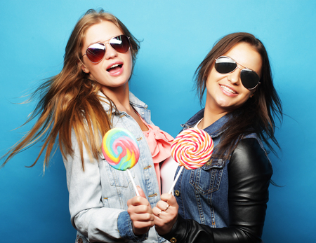 two sisters, best friends over blue backgroundの写真素材