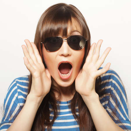Portrait of beautiful young girl in sunglasses a look of surpriseの写真素材