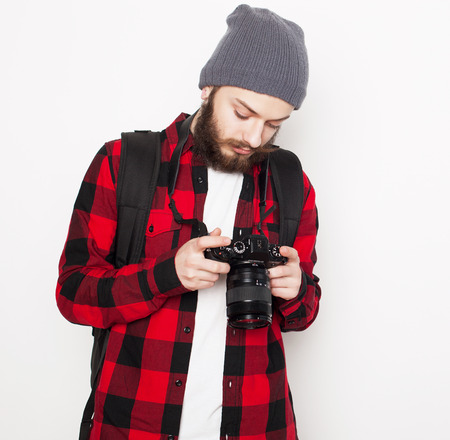 Life style, technology and people concept: professional photographer. Portrait of confident young man in shirt  holding  camera over white の写真素材