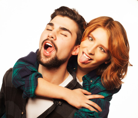 Life style, happiness and people concept: Happy loving couple. Young man piggybacking his girlfriend. Studio shot over white .Special Fashionable toning photos.の写真素材
