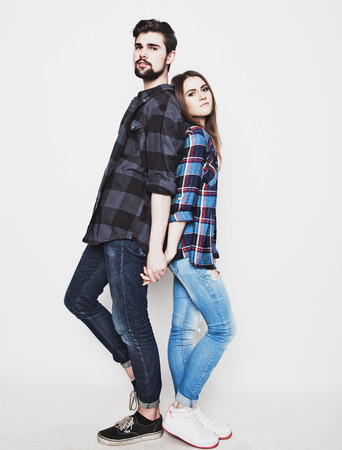 life style, happiness and people concept: Hipster couple. Beautiful young loving couple pposing  while standing against white  background.の写真素材