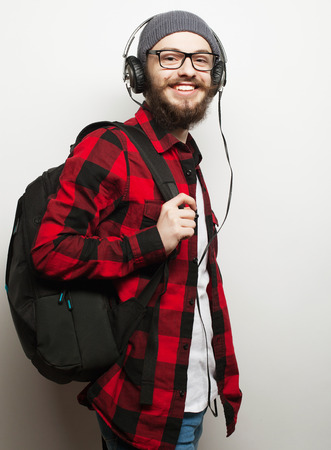 life style, education and people concept:  young bearded man listening to music while standing against grey background. Hipster style.の写真素材